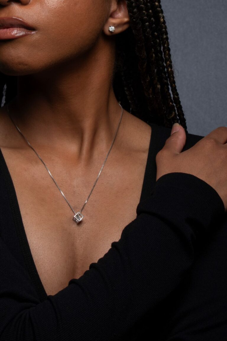 a young women wearing a necklace and earrings.