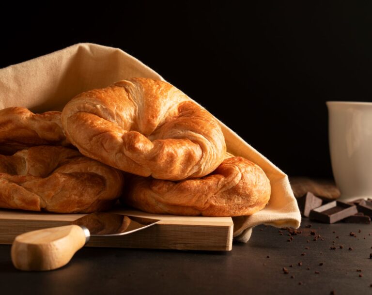 freshly baked croissants on the left with chocolate on the right and a mug.